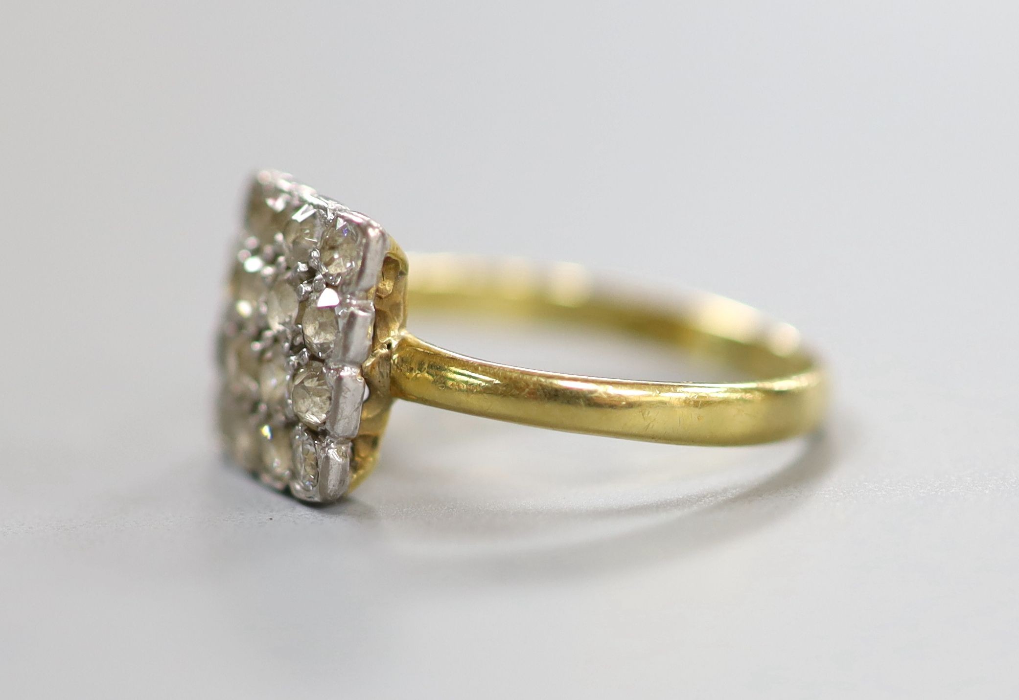An 18ct and sixteen stone diamond set cluster tablet ring, size O, gross 2.5 grams.